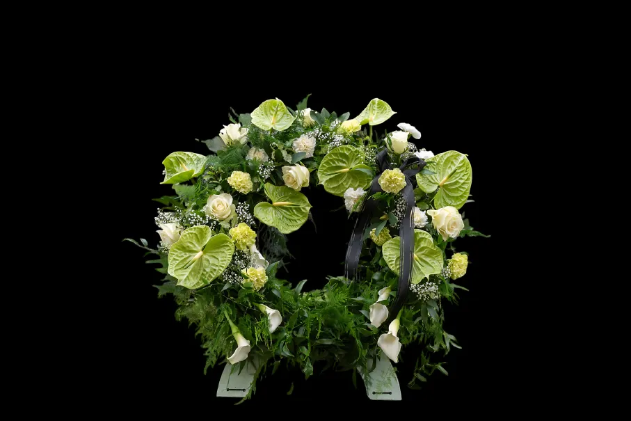 A circular floral arrangement with white and green flowers.
